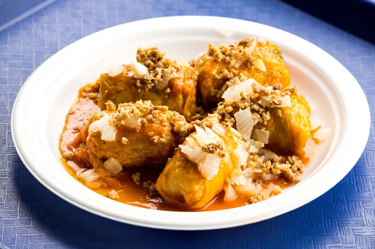 Cabbage rolls in tomato sauce topped with onions and bacon bits